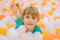 Child playing in ball pit. Colorful toys for kids. Kindergarten or preschool play room. Toddler kid at day care indoor Royalty Free Stock Photo