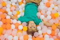 Child playing in ball pit. Colorful toys for kids. Kindergarten or preschool play room. Toddler kid at day care indoor Royalty Free Stock Photo