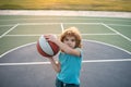 Child playing basketball. Cute little boy holding a basket ball trying make a score. Sport for kids. Royalty Free Stock Photo