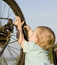 Child playing with bike wheel
