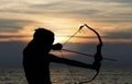 Child playing bow and arrow on the beach, Silhouette