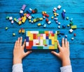 Child playing and building with colorful toy bricks, plastic blocks