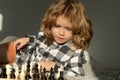 Child playing chess at home. Chess school. Child think about chess game. Intelligent, smart and clever school kid pupil Royalty Free Stock Photo