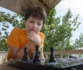 Child playing chess outdors, Young boy making a move Royalty Free Stock Photo