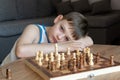 The serious child lost in thought playing chess. Playing board games, on coronavirus quarantine. The child playing chess Royalty Free Stock Photo