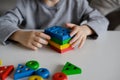 A child is playing with a colored educational wooden toy. Children& x27;s Wooden Toy