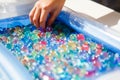 child playing with colored glass ball, playing game with colored balls