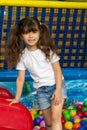 Child playing with colorful balls in playground ball pool. Activity toys for little kid. Kids happiness emotion having fun in ball Royalty Free Stock Photo