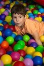 Child playing with colorful balls in playground ball pool. Activity toys for little kid. Kids happiness emotion having fun in ball Royalty Free Stock Photo