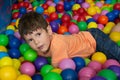 Child playing with colorful balls in playground ball pool. Activity toys for little kid. Kids happiness emotion having fun in ball Royalty Free Stock Photo