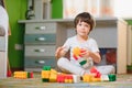 Child playing with colorful toy blocks. Little boy building tower at home or day care. Educational toys for young children.