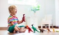 Child playing with toy dinosaurs. Kids toys