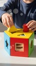 Child playing with a colorful wooden shape sorter toy. Educational game for kid development Royalty Free Stock Photo