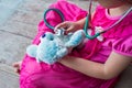 Child playing doctor or nurse with plush toy bear at home. Royalty Free Stock Photo