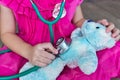 Child playing doctor or nurse with plush toy bear at home. Royalty Free Stock Photo