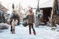 Child playing with dog outdoor in snowy winter garden