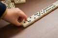 Child playing dominoes on wooden table Royalty Free Stock Photo