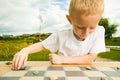 Child playing draughts or checkers board game outdoor Royalty Free Stock Photo