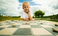 Child playing draughts or checkers board game outdoor Royalty Free Stock Photo