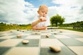 Child playing draughts or checkers board game outdoor Royalty Free Stock Photo