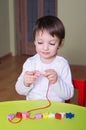 Child playing with educational toys beading