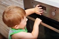 Child playing with electric oven. Royalty Free Stock Photo