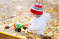 Child playing excavator on the street