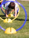 Child playing in a exercising circle - tunnel tube, crawling through it and having fun