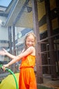 Child playing with garden sprinkler. Summer outdoor water fun in backyard. Ggirl play with hose watering grass. Kid Royalty Free Stock Photo