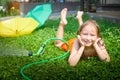 Child playing with garden sprinkler. Summer outdoor water fun in backyard. Ggirl play with hose watering grass. Kid Royalty Free Stock Photo