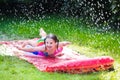 Child playing with garden water slide Royalty Free Stock Photo