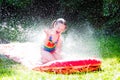Child playing with garden water slide Royalty Free Stock Photo
