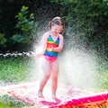 Child playing with garden water slide Royalty Free Stock Photo