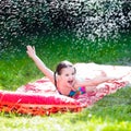 Child playing with garden water slide Royalty Free Stock Photo