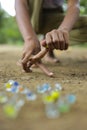 A child playing with glass marbles which is an old Indian village game. Glass Marbles are also called as Kancha in Hindi Language Royalty Free Stock Photo