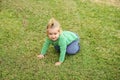 Child is playing on the grass. Baby boy sitting and having fun on meadow grass Royalty Free Stock Photo