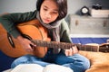 Child Playing Guitar in Her Bedroom