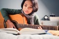 Child Playing Guitar in Her Bedroom