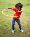 Child, playing and hula hoop on field on vacation, green grass and sunshine with happiness in city. Young boy, mexican