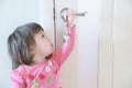 Child playing with keys forgotten by parents in door keyhole. Children safety and home safety