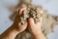 Child playing with kinetic sand. Baby`s sensory experiences