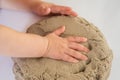 Child playing with kinetic sand. Baby`s sensory experiences