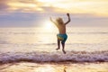 Child playing on ocean beach. Kid at sunset sea