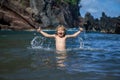 Child playing in ocean water. Kid jumping in the sea waves. Kids vacation on beach. Little excited boy swimming during Royalty Free Stock Photo