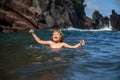 Child playing in ocean water. Kid jumping in the sea waves. Kids vacation on beach. Little excited boy swimming during Royalty Free Stock Photo