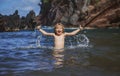 Child playing in ocean water. Kid jumping in the sea waves. Kids vacation on beach. Little excited boy swimming during Royalty Free Stock Photo