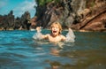 Child playing in ocean water. Kid jumping in the sea waves. Kids vacation on beach. Little excited boy swimming during Royalty Free Stock Photo