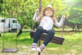 Child playing in the open playground, little happy laughing girl swinging on a swing Royalty Free Stock Photo