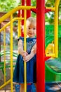 Child playing on outdoor playground. Little baby girl plays on school or kindergarten yard. Active kid on colorful swing Royalty Free Stock Photo