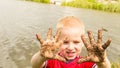 Child playing outdoor showing dirty muddy hands. Royalty Free Stock Photo